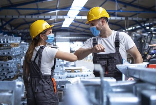 Factory workers greeting each others with elbows during corona v Factory workers greeting each others with elbows during corona v